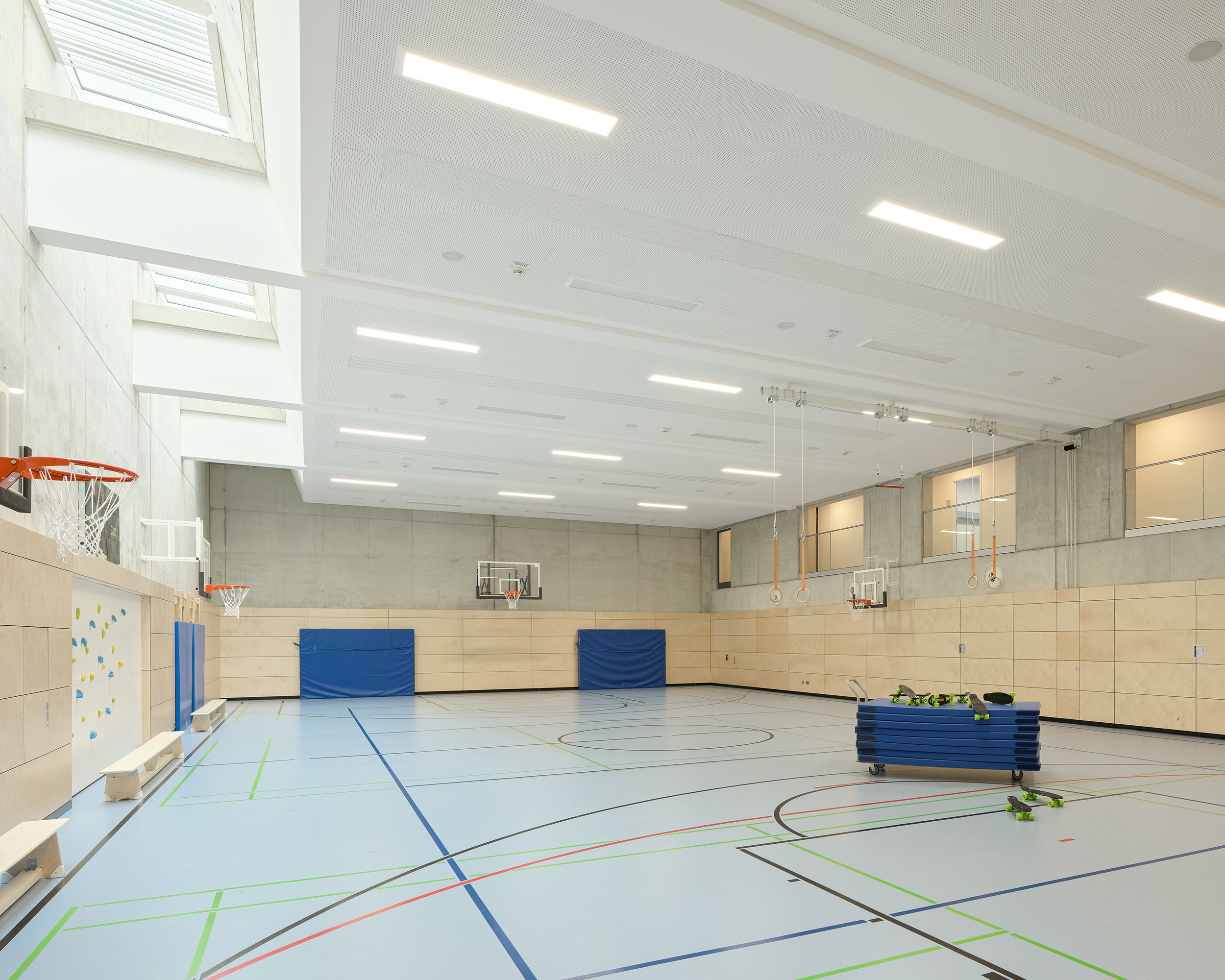 Eine Sporthalle mit hellem Boden, Holzwänden, einer Galerie und einem Oberlicht.
